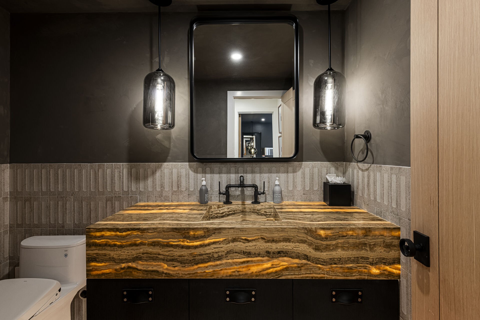 Sun Peak Manor House - Powder room where the light shines through the stone counter